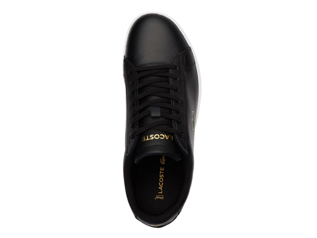 Tenis Lacoste color negro con suela blanca y logotipo del cocodrilo en el costado.