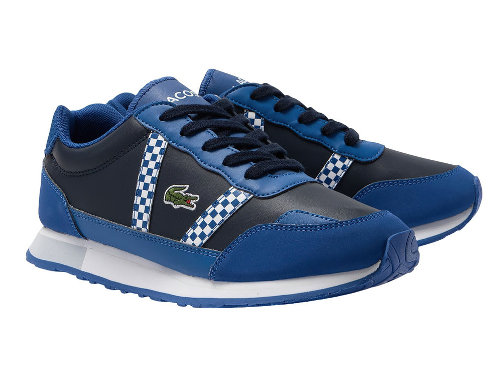 Tenis deportivos Lacoste para niños en azul marino y azul real con detalles de cuadros blancos y suela blanca.