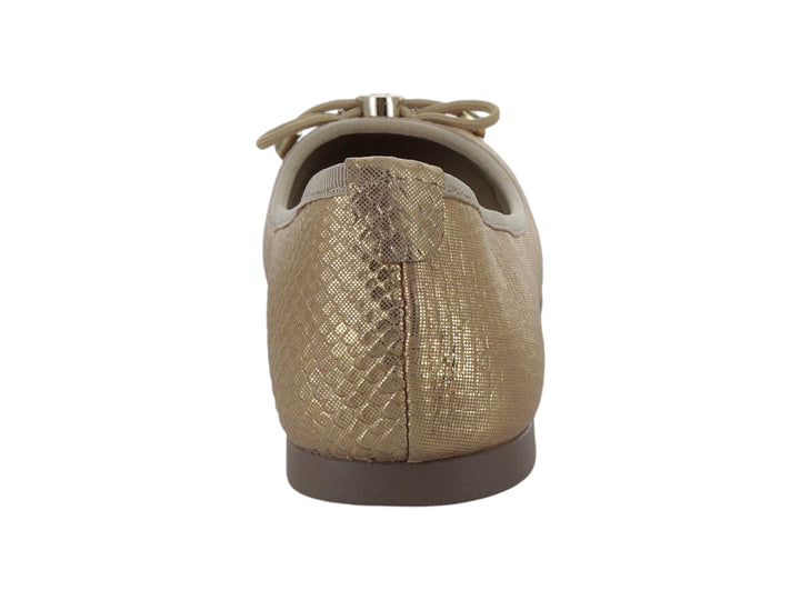 Zapato plano tipo baleta color platinum con acabado brillante y detalle de moño decorativo en la punta.