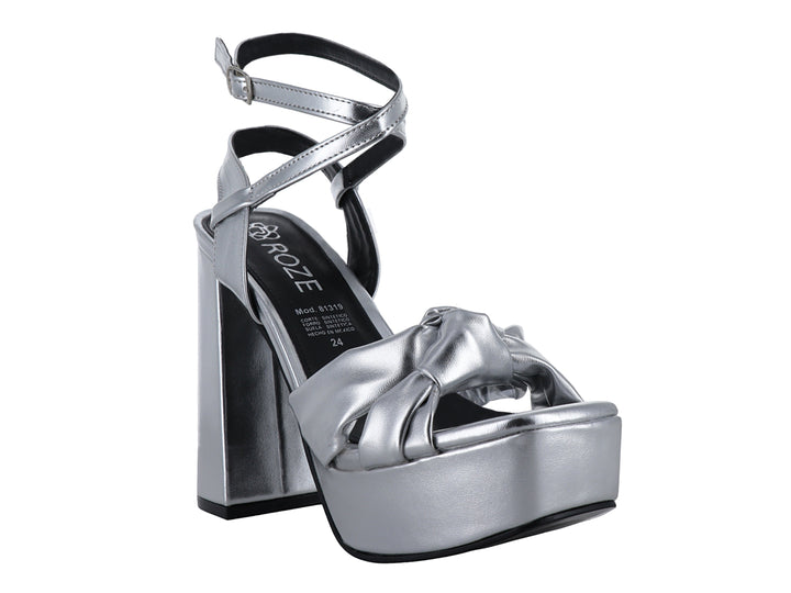 Sandalia de mujer color plata metálico con tacón grueso, plataforma y detalle de nudo en la parte frontal.
