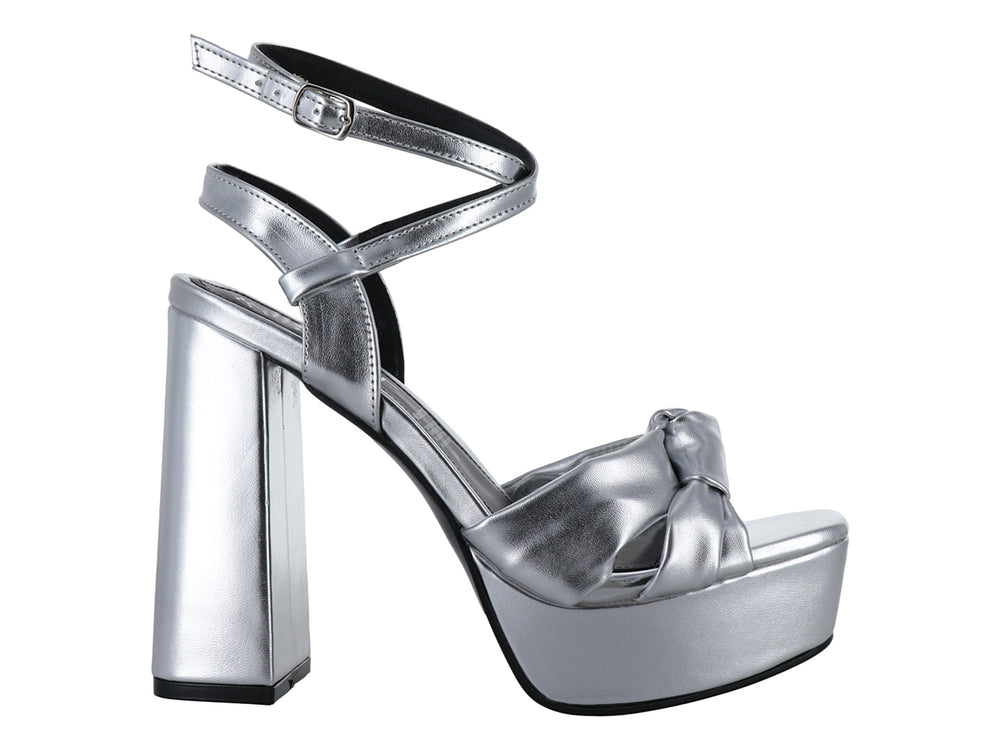 Sandalia de mujer color plata metálico con tacón grueso, plataforma y detalle de nudo en la parte frontal.