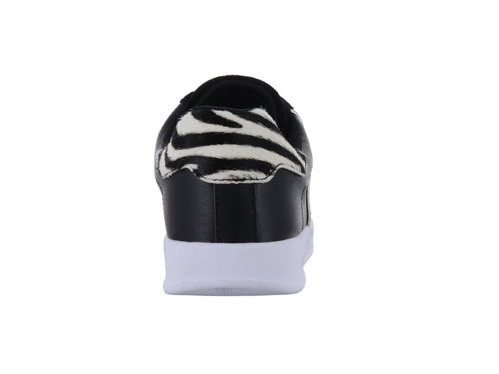 Tenis Guess negros con detalles blancos en forma de V y suela blanca.