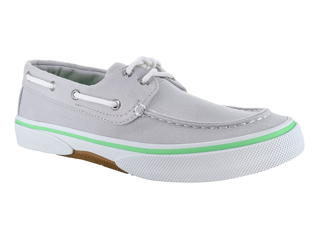 Zapato náutico Sperry de color gris con cordones blancos y una línea verde decorativa en la suela blanca.