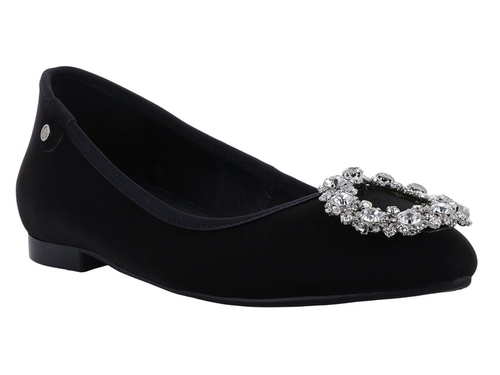 Zapato plano negro de terciopelo con un broche circular de cristales brillantes en la punta.