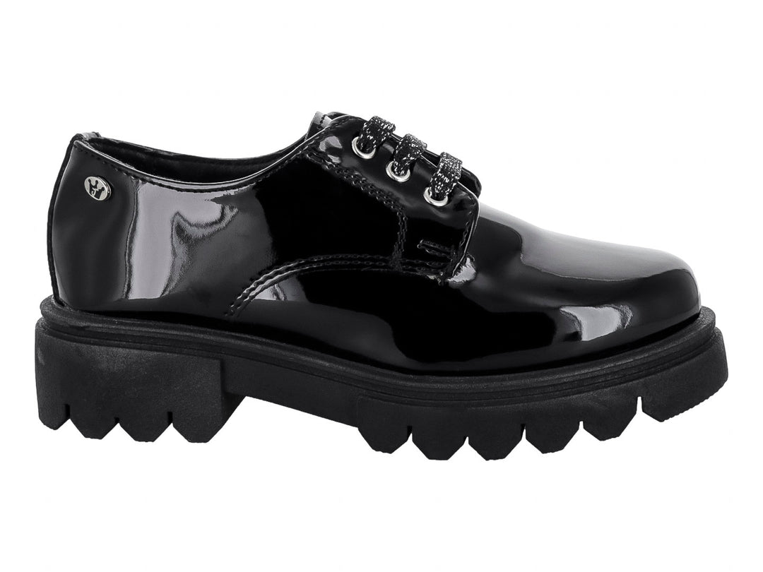 Zapato negro de charol con suela track gruesa y agujetas brillantes.