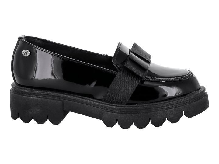 Zapato mocasín infantil de charol negro con moño y suela track gruesa.