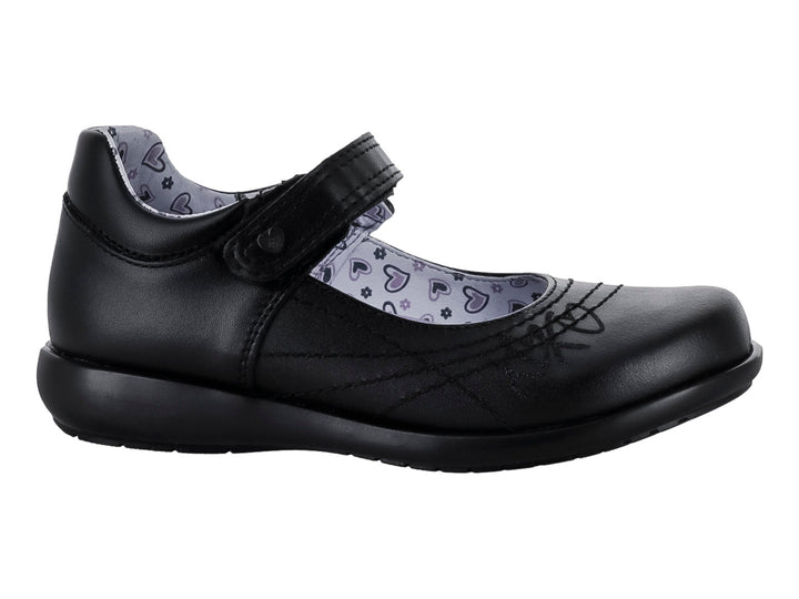Zapato negro para niña de material sintético con correa de cierre y forro interior estampado de corazones.