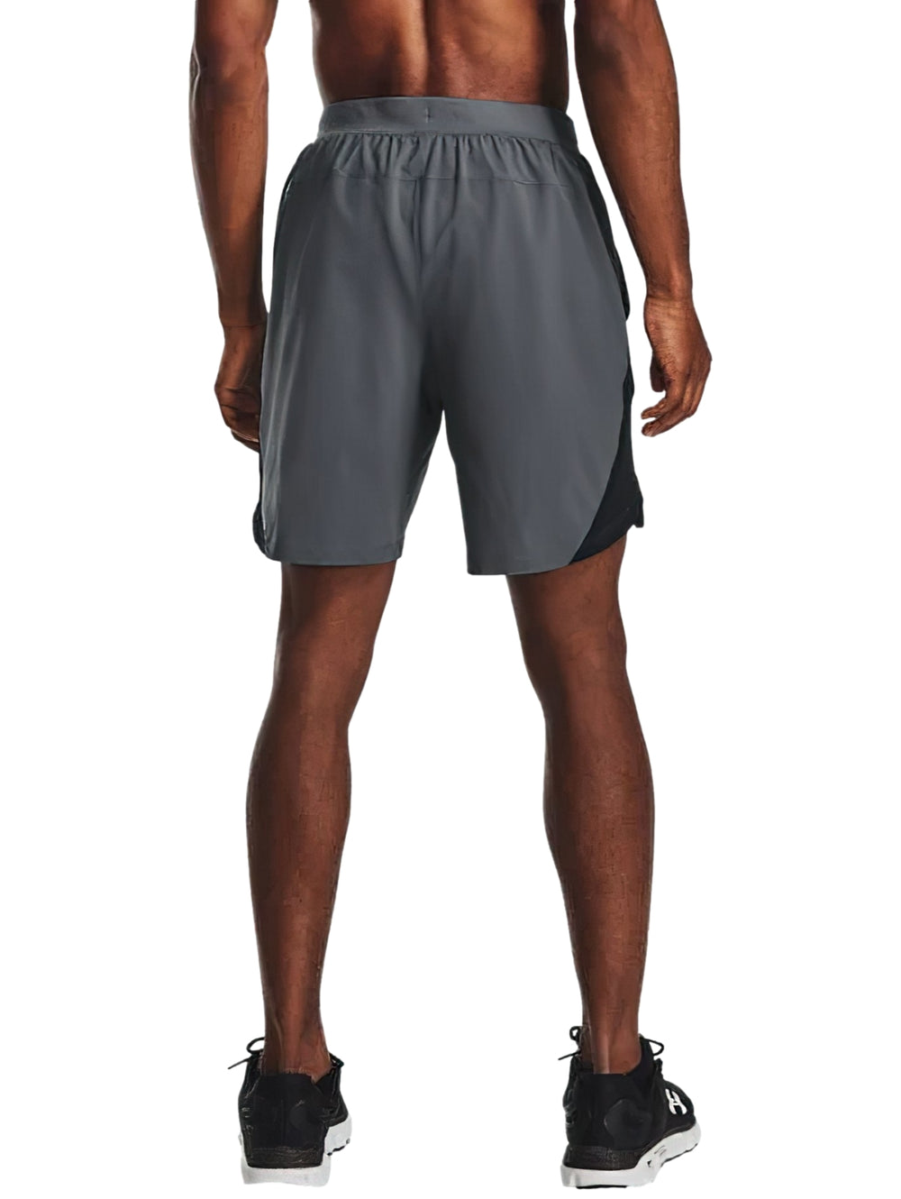 Hombre vistiendo shorts deportivos Under Armour de color gris con corte a 7 pulgadas.