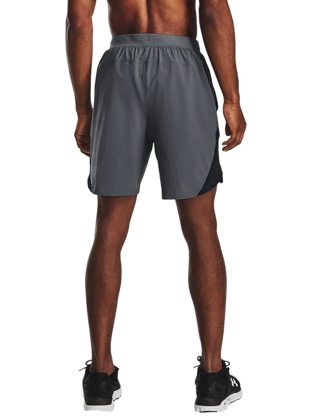 Hombre vistiendo shorts deportivos Under Armour de color gris con corte a 7 pulgadas.