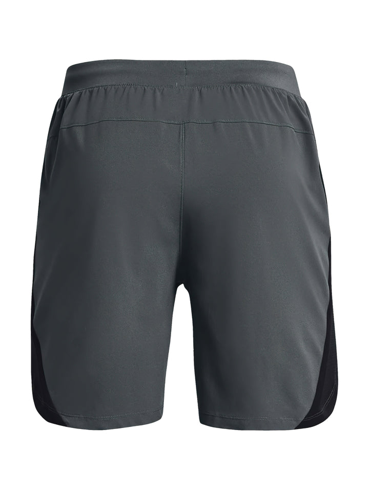 Hombre vistiendo shorts deportivos Under Armour de color gris con corte a 7 pulgadas.