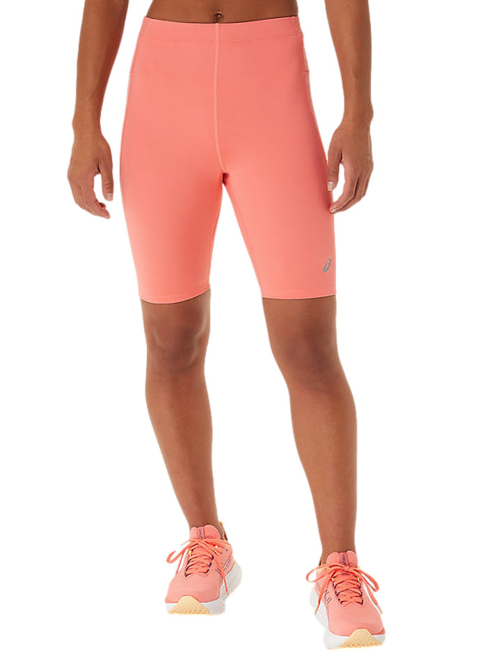 Mujer vistiendo pantalones cortos deportivos ASICS Race Sprinter Tight en color papaya.
