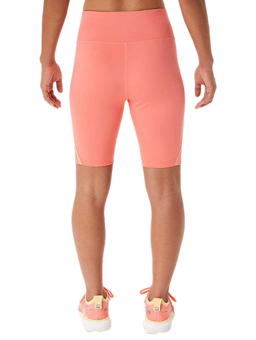Mujer vistiendo pantalones cortos deportivos ASICS Race Sprinter Tight en color papaya.