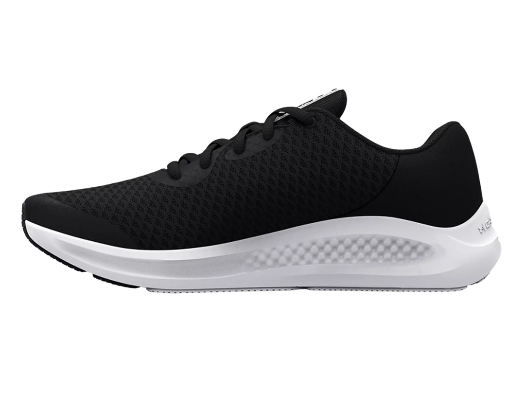 Tenis deportivos Under Armour para niños en color negro con suela blanca y logotipo blanco lateral.