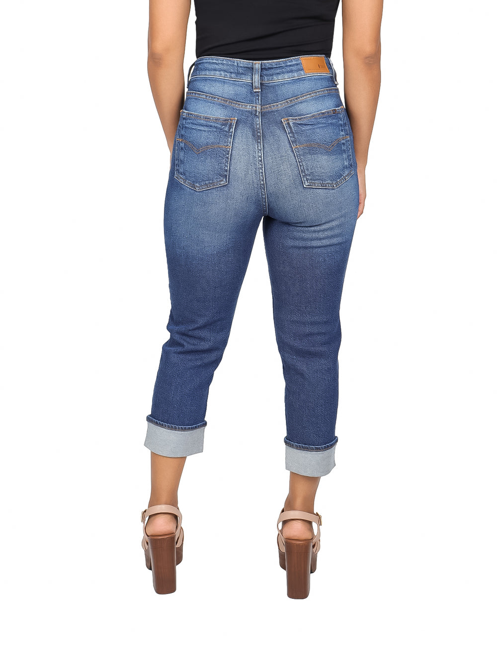 Mujer vistiendo pantalones capri de mezclilla azul ajustados con dobladillos doblados