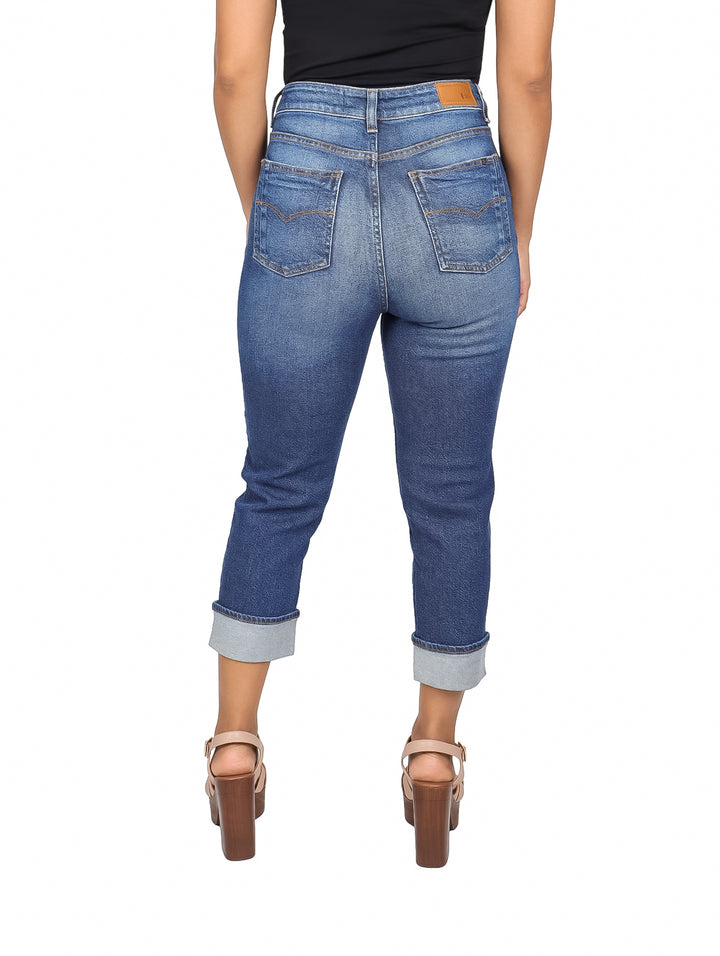 Mujer vistiendo pantalones capri de mezclilla azul ajustados con dobladillos doblados
