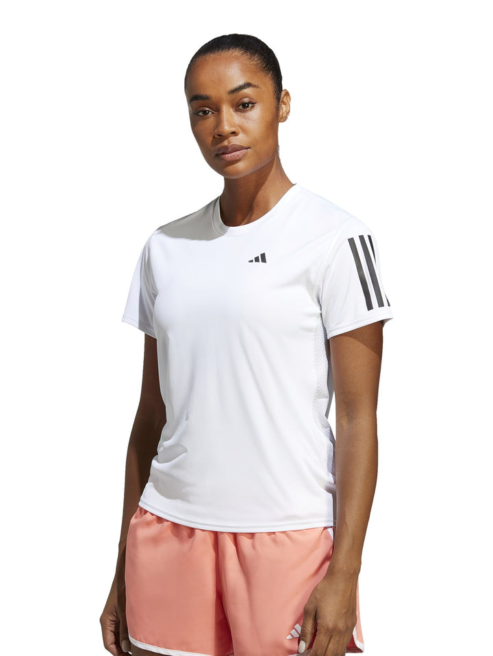 Mujer vistiendo camiseta deportiva blanca Adidas Own The Run con rayas negras en el hombro.