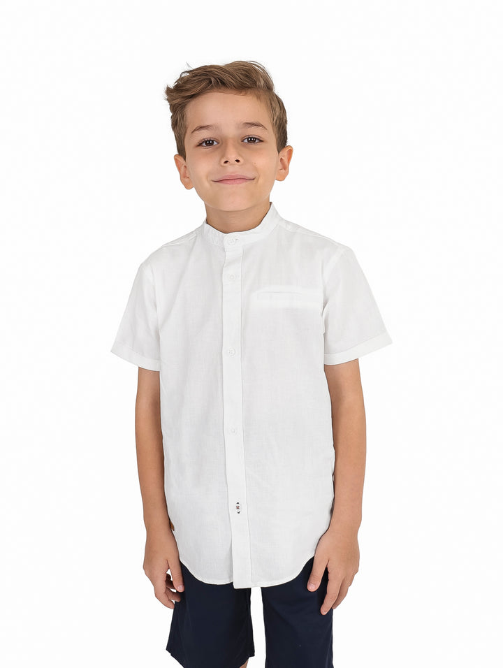 Niño vistiendo una camisa blanca de manga corta con cuello mao y botones frontales.