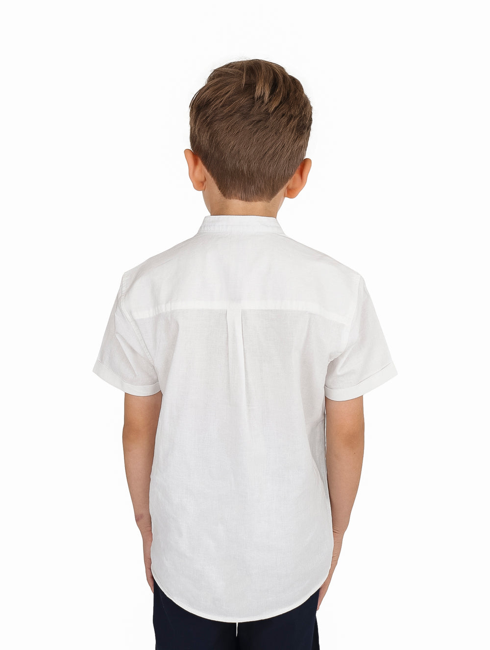 Niño vistiendo una camisa blanca de manga corta con cuello mao y botones frontales.