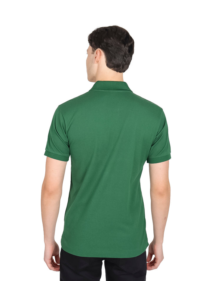 Hombre vistiendo playera polo Lacoste de color verde con cuello y manga corta sobre fondo blanco.