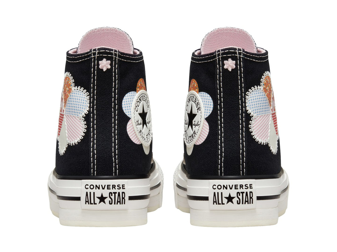 Tenis Converse Chuck Taylor All Star de caña alta en color negro con suela blanca y detalle floral colorido.