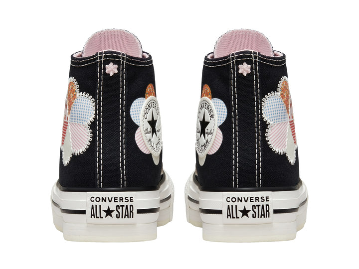 Tenis Converse Chuck Taylor All Star de caña alta en color negro con suela blanca y detalle floral colorido.