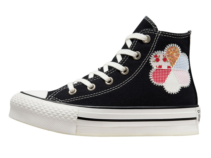 Tenis Converse Chuck Taylor All Star de caña alta en color negro con suela blanca y detalle floral colorido.