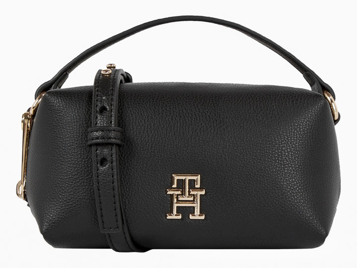 Bolso cilíndrico de cuero negro Tommy Hilfiger con logo dorado y asa superior.