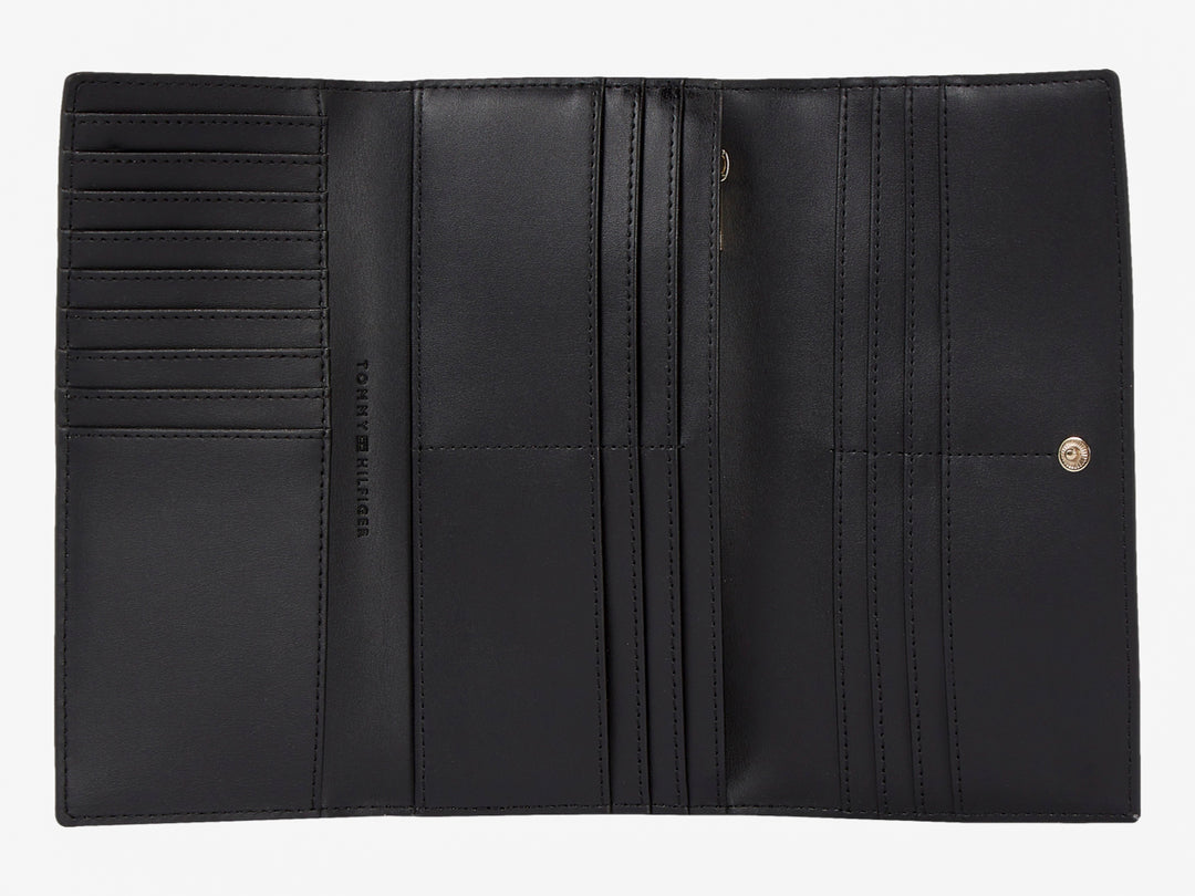 Bolso estilo cartera color negro de cuero con logotipo dorado de Tommy Hilfiger al centro.