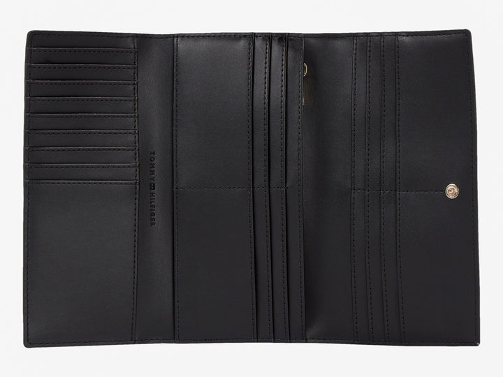 Bolso estilo cartera color negro de cuero con logotipo dorado de Tommy Hilfiger al centro.