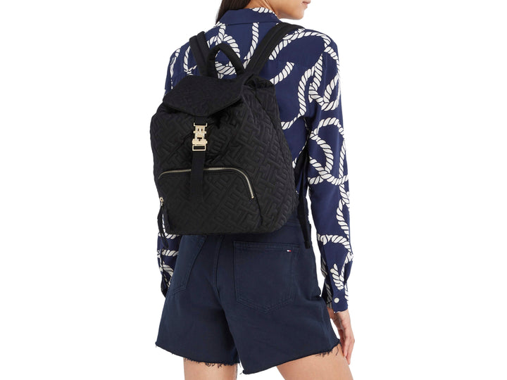 Mochila negra Tommy Hilfiger con patrón en relieve y cierre metálico dorado.
