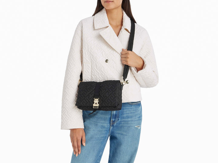 Bolso bandolera negro acolchado con cierre metálico plateado.