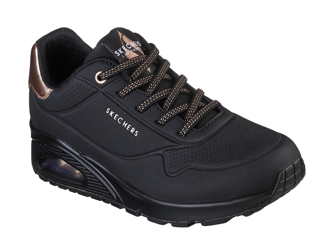 Tenis deportivos Skechers color negro con detalle metálico en el talón y cámara de aire en la suela.