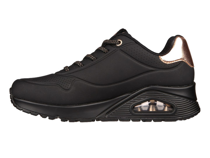 Tenis deportivos Skechers color negro con detalle metálico en el talón y cámara de aire en la suela.