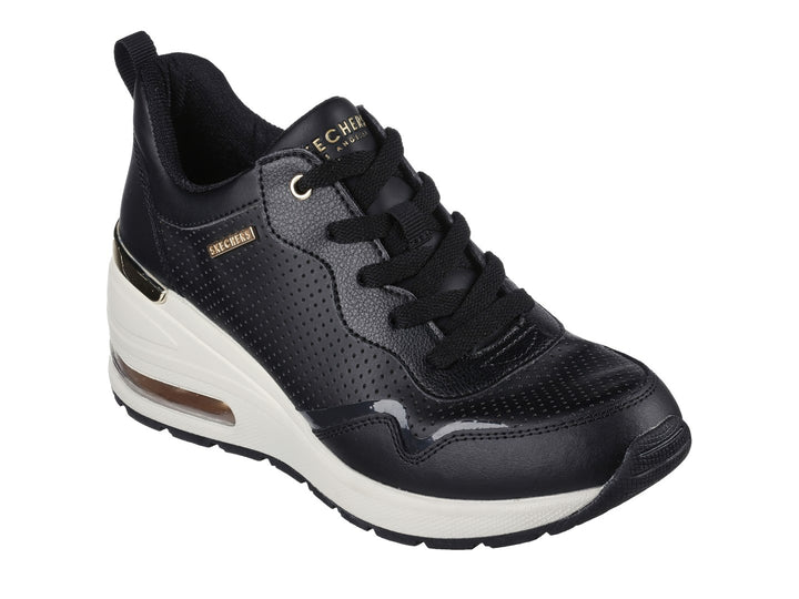 Tenis Skechers negros con suela blanca y detalles dorados.