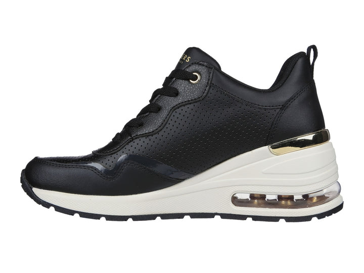Tenis Skechers negros con suela blanca y detalles dorados.