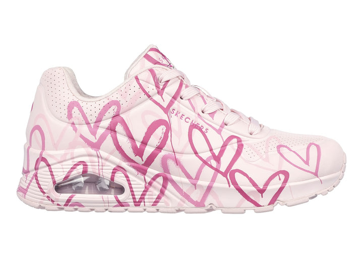 Tenis Skechers rosa con estampado de corazones y cámara de aire en el talón.