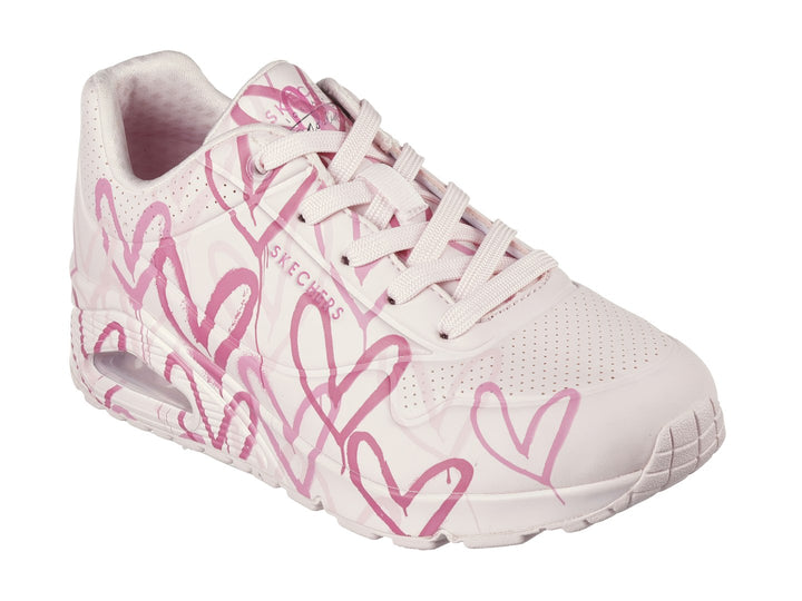 Tenis Skechers rosa con estampado de corazones y cámara de aire en el talón.