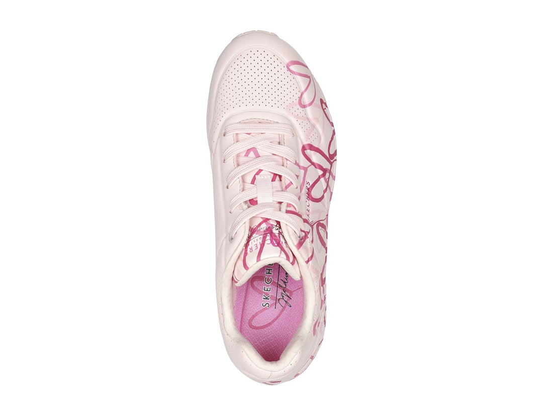 Tenis Skechers rosa con estampado de corazones y cámara de aire en el talón.