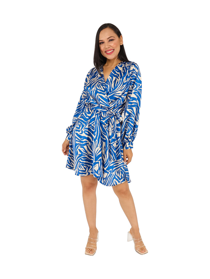 Mujer con vestido camisero corto estampado en colores azul rey y blanco con cinturón.