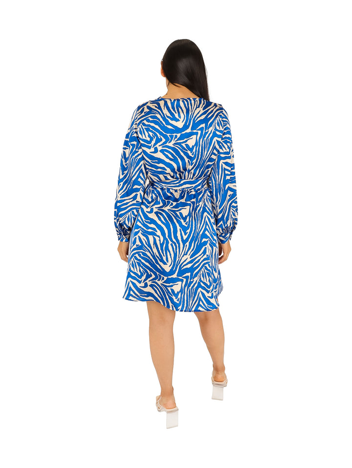 Mujer con vestido camisero corto estampado en colores azul rey y blanco con cinturón.