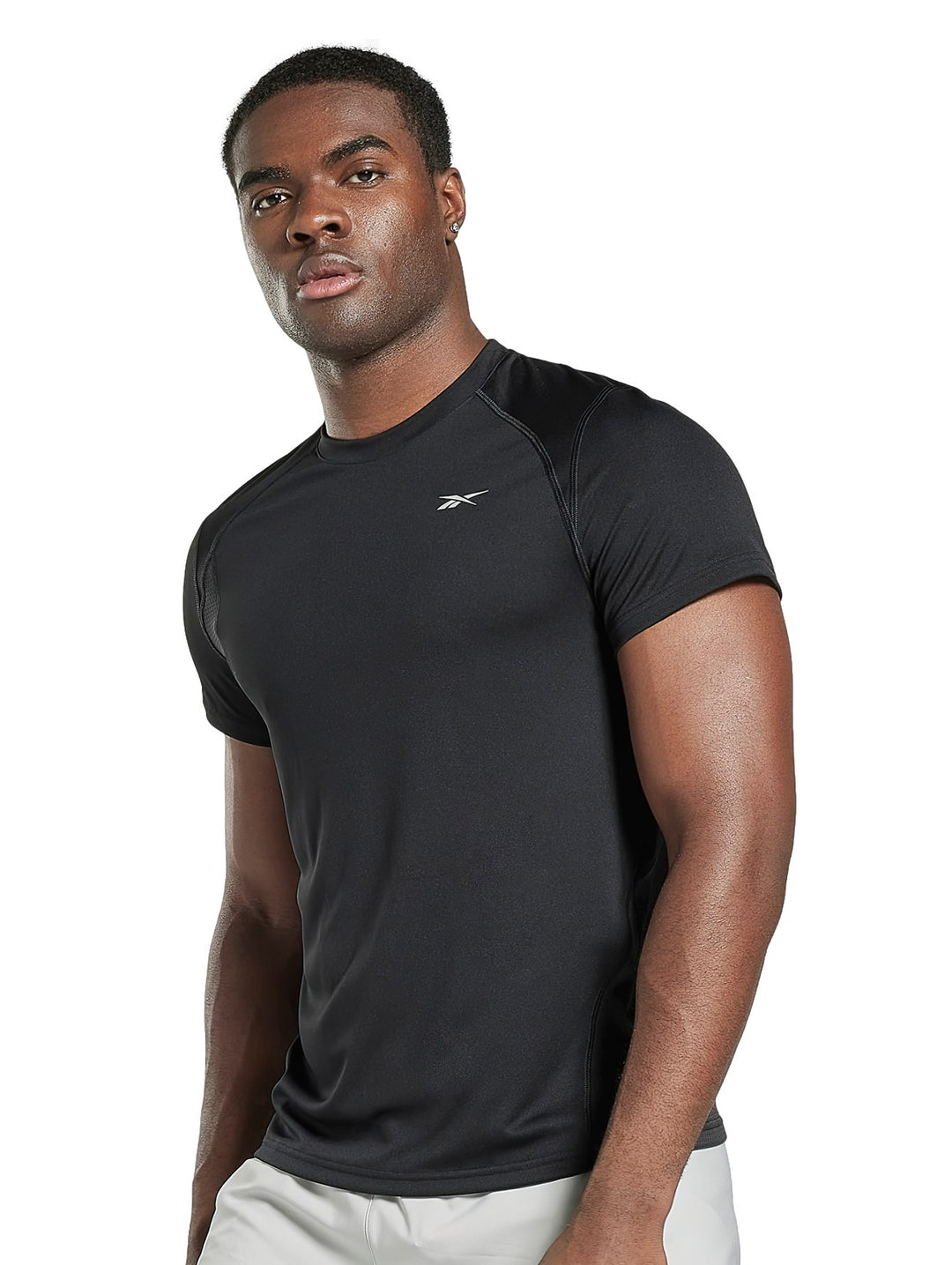 Hombre vistiendo camiseta deportiva de manga corta color negro marca Reebok.