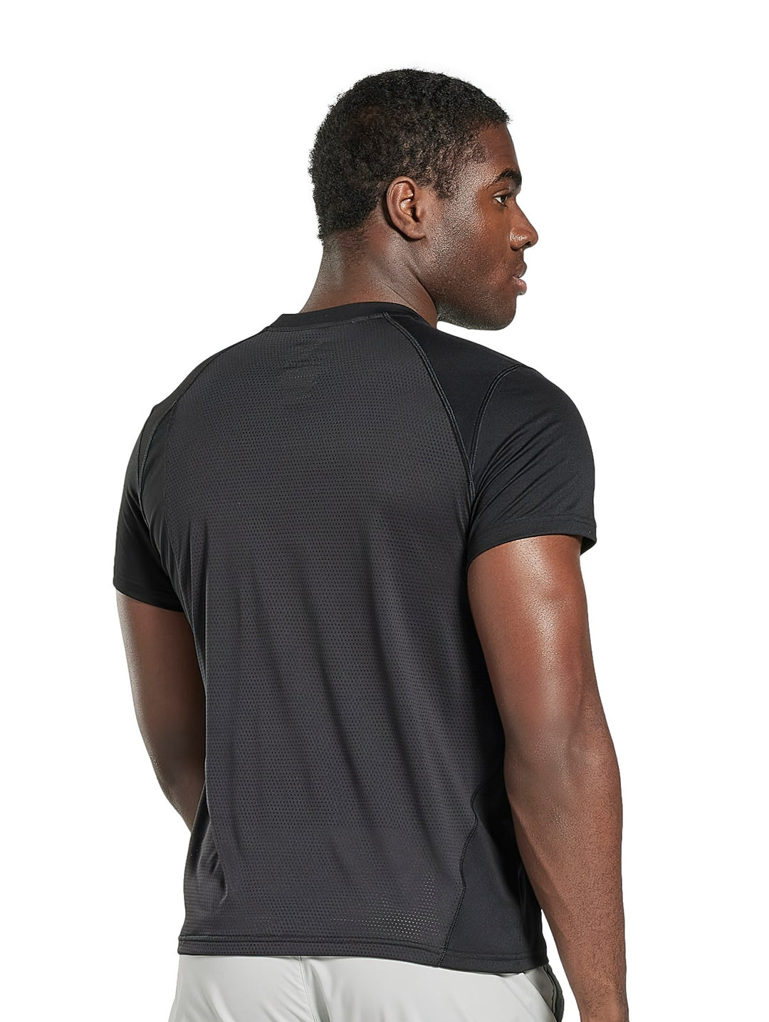 Hombre vistiendo camiseta deportiva de manga corta color negro marca Reebok.