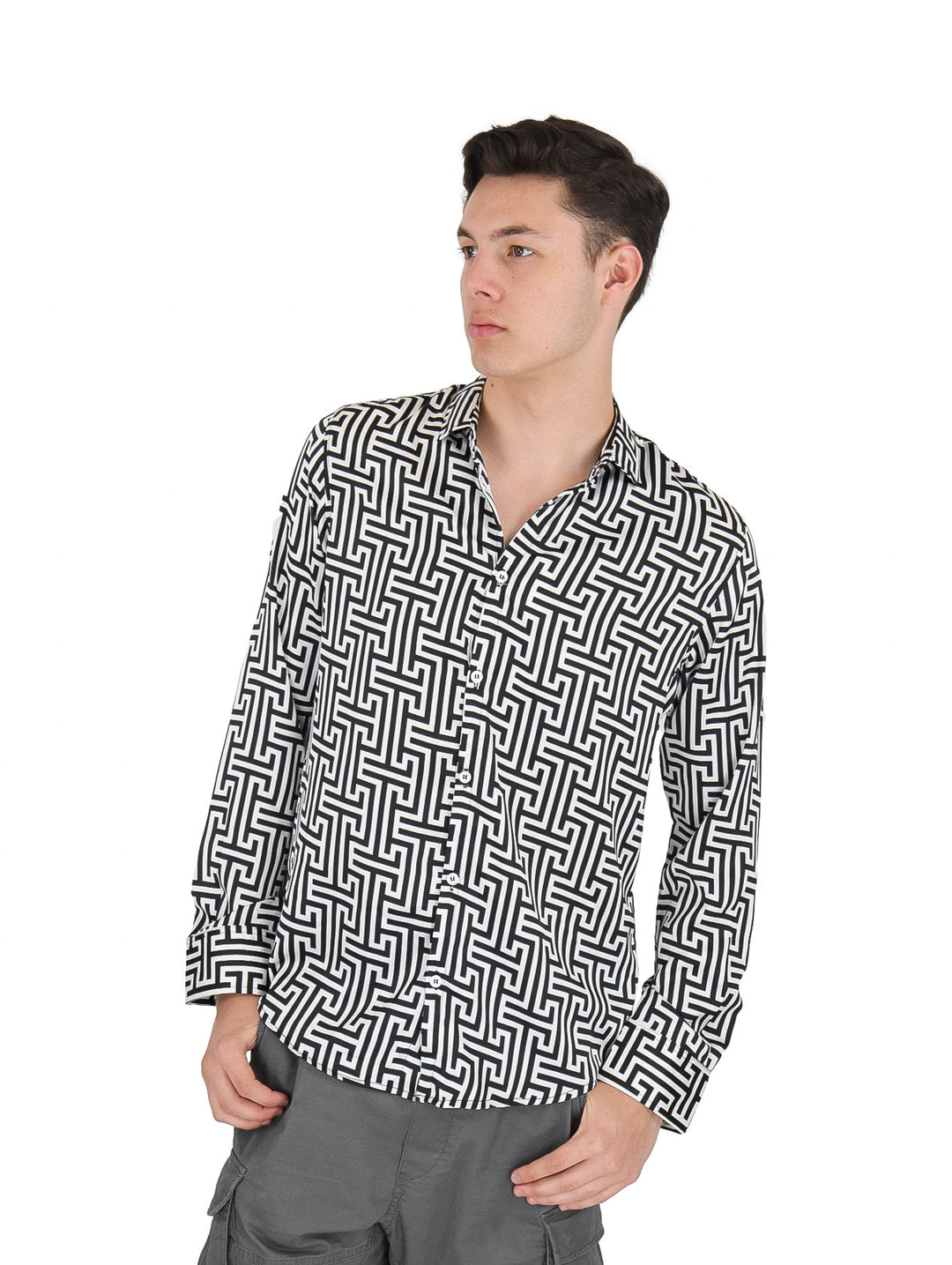 Hombre vistiendo una camisa de manga larga con estampado geométrico en colores blanco y negro.