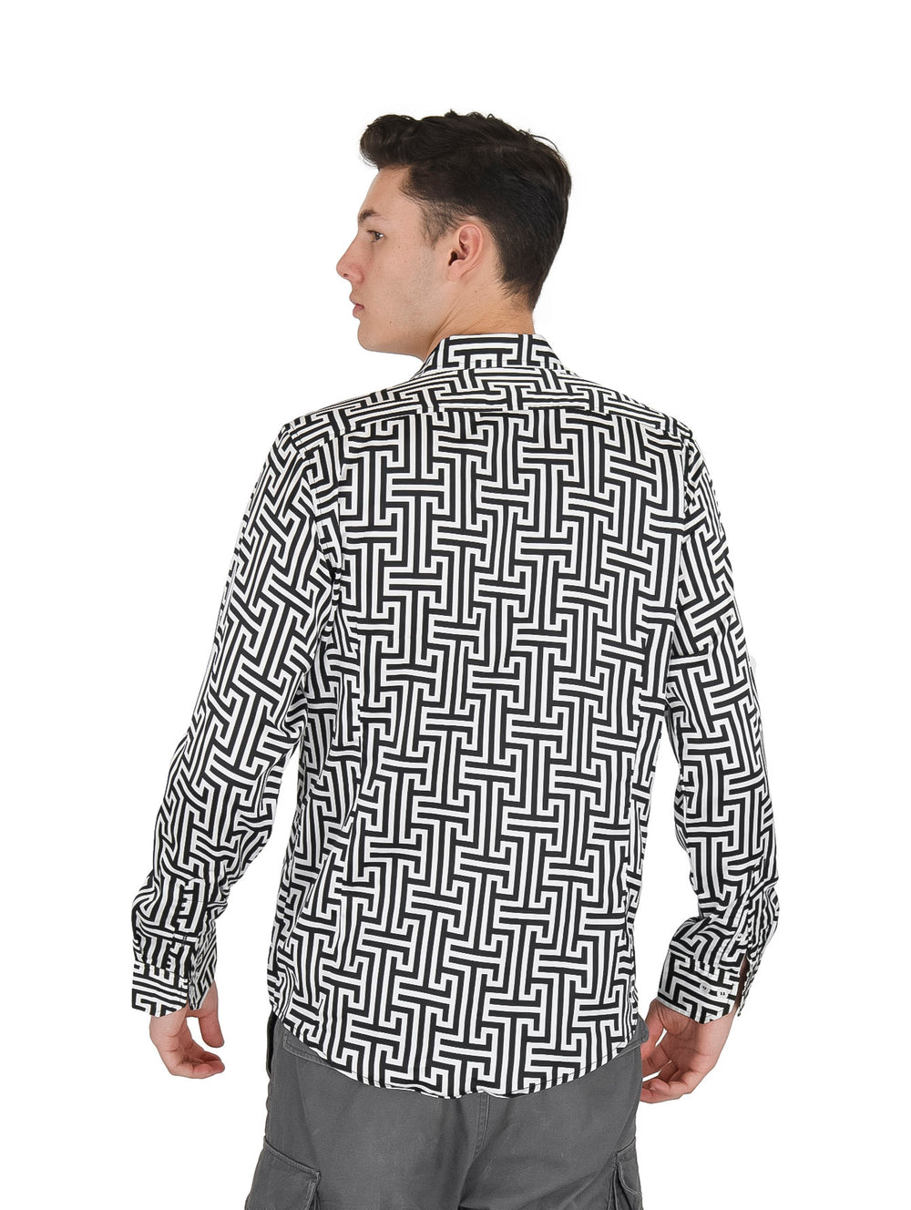 Hombre vistiendo una camisa de manga larga con estampado geométrico en colores blanco y negro.