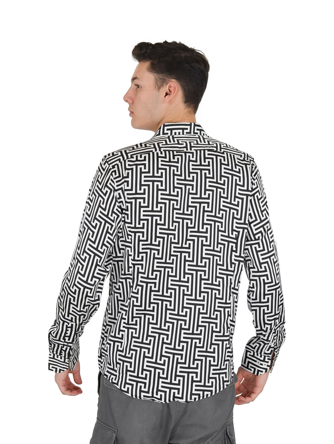 Hombre vistiendo una camisa de manga larga con estampado geométrico en colores blanco y negro.