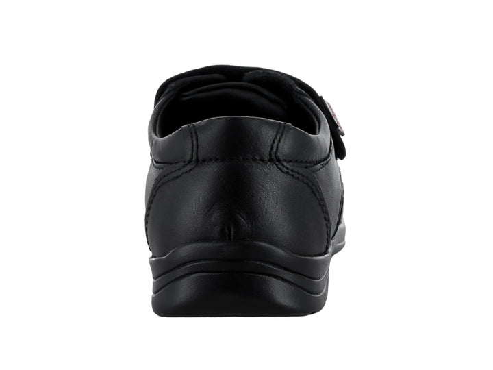 Zapato infantil color negro con cierre de velcro y acabado mate.