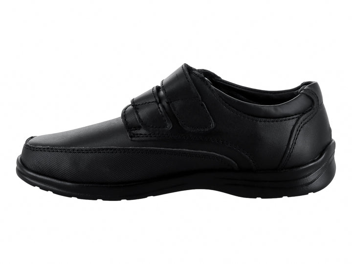 Zapato infantil color negro con cierre de velcro y acabado mate.