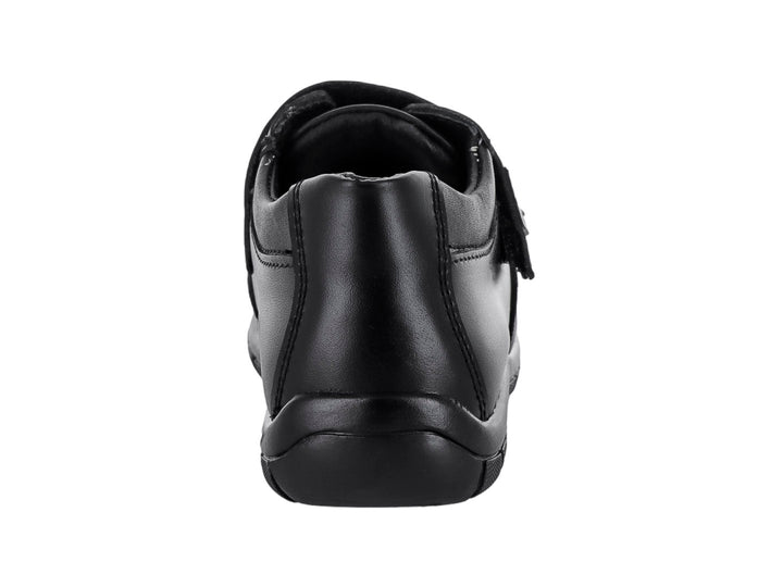Zapato infantil color negro con cierre de velcro y punta texturizada.