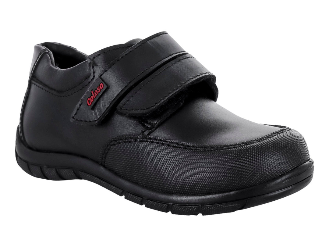 Zapato infantil color negro de material sintético con cierre de velcro.