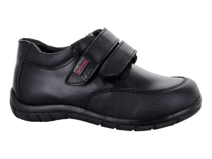 Zapato infantil color negro de material sintético con cierre de velcro.